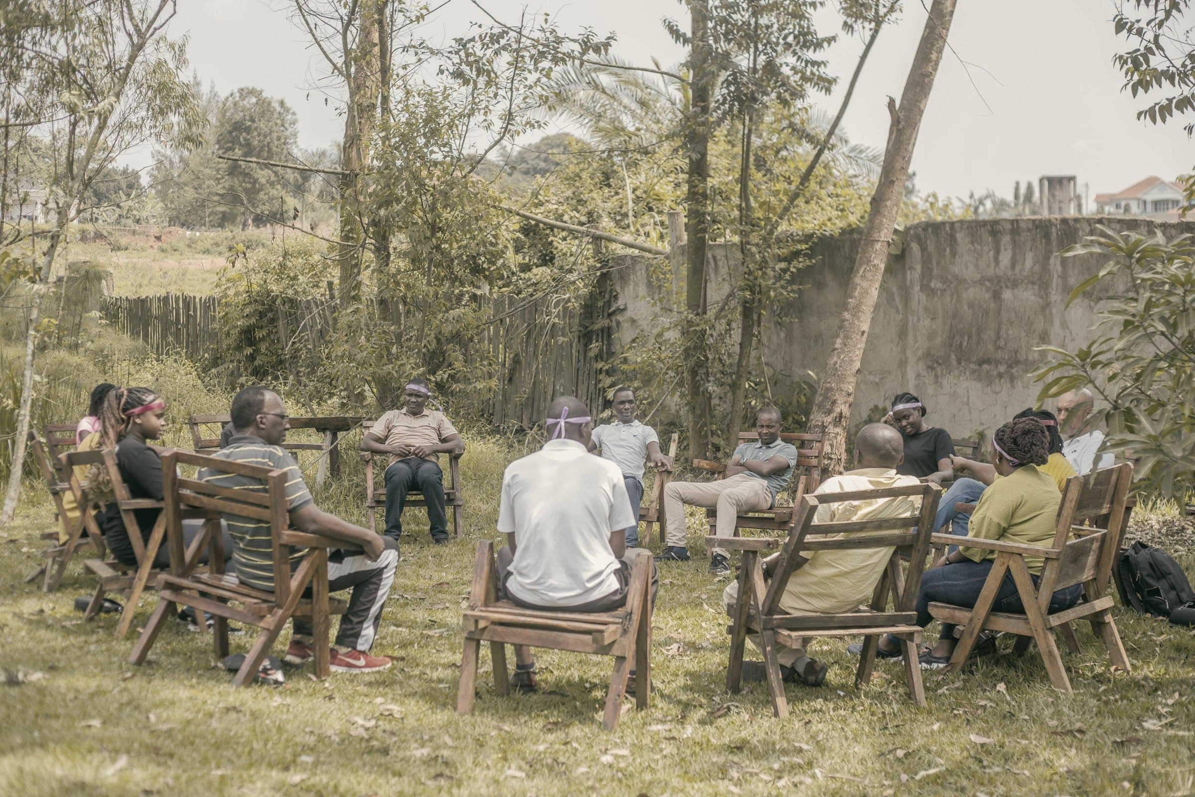 A team meeting held in a circle outdoors, everyone engaged in the discussion